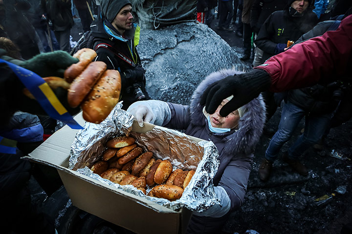 Ukraine: A woman in Kiev hads out bread rolls to protestors