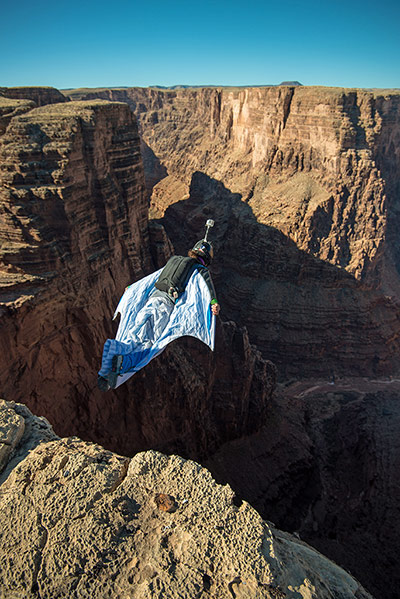 BASE jumping in Utah: A parachutist wearing a wingsuit dives from the cliff edge