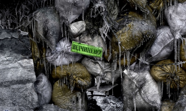 A frozen road block in Kiev with a door sign reading 'open'.