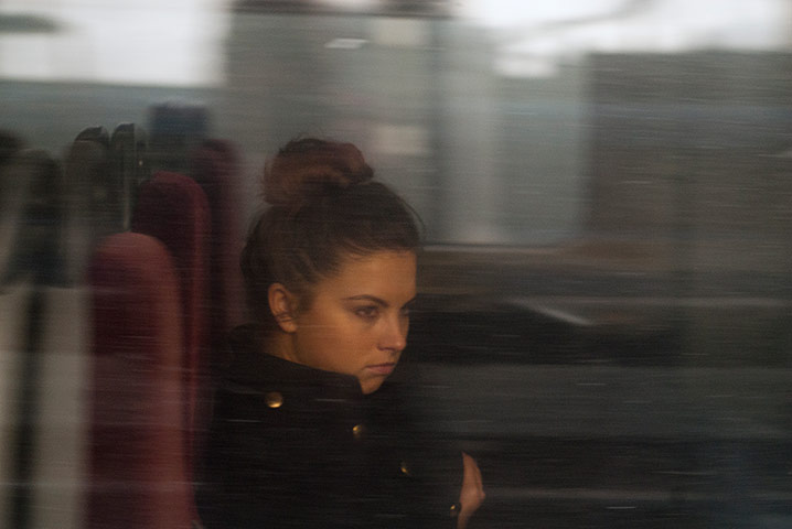Big Picture - Commuters: young woman looking out from train window