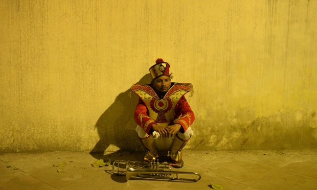 Blow your own trumpet: An Indian band member waits at the roadside ahead of the bridal procession in New Delhi.