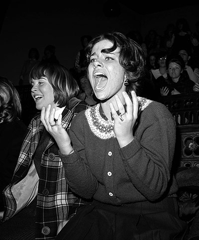 Beatles in America: A screaming fan watches the band perform on stage at Carnegie Hall, New York