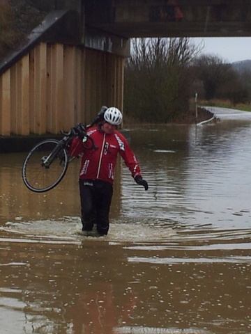 Flood waters under the railway bridge interrupt the normal routine of Saturday morning cyclists near the Vale of the White Horse,