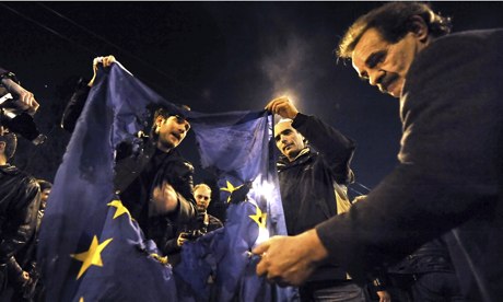 Greek demonstrators burn an EU flag