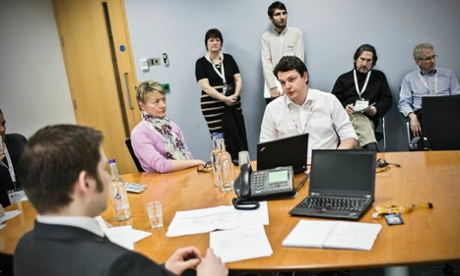 Two contestants brief PWC's Andrew Miller on Koffee Cafe's problems, while Alex Hern (standing) observes in the background.