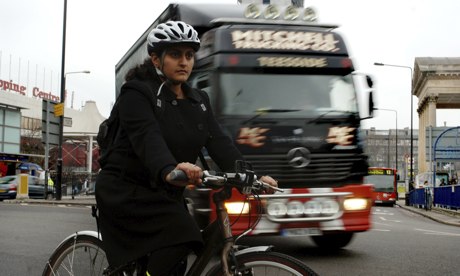 A cyclist negotiates the Elephant and Castle roundabout in London with a lorry behind
