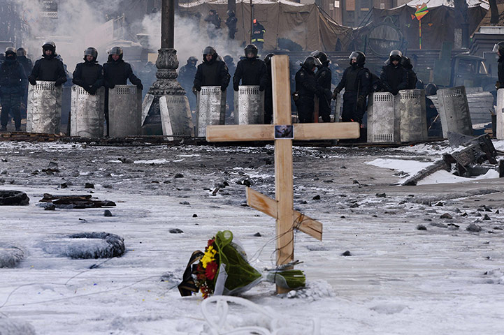 20 Photos: A cross is placed in front of riot policemen at a road block in Kiev