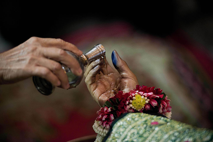 20 Photos: Water is poured onto the hand of Suthin Tharathin In Bangkok