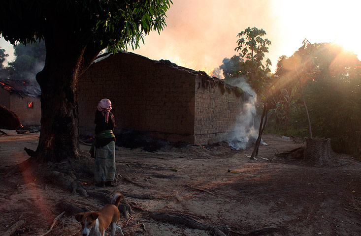 20 Photos: A woman looks at burning houses in Bossangoa, Central African Republic