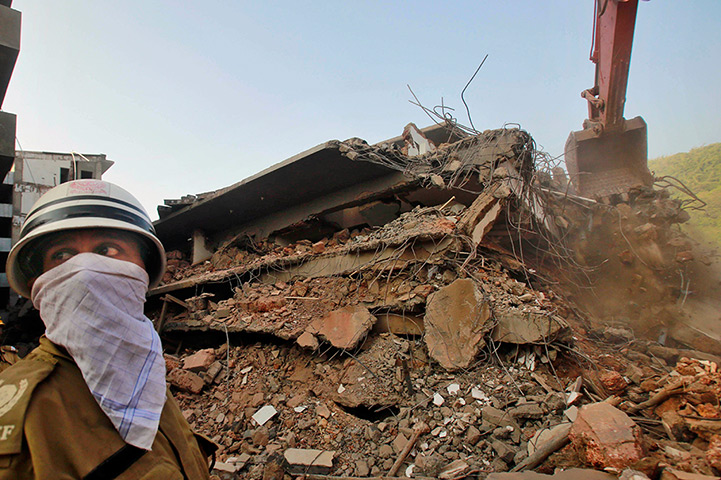 Weekend in pictures: A rescue worker watches as a power shovel clears debris at the site of a bu