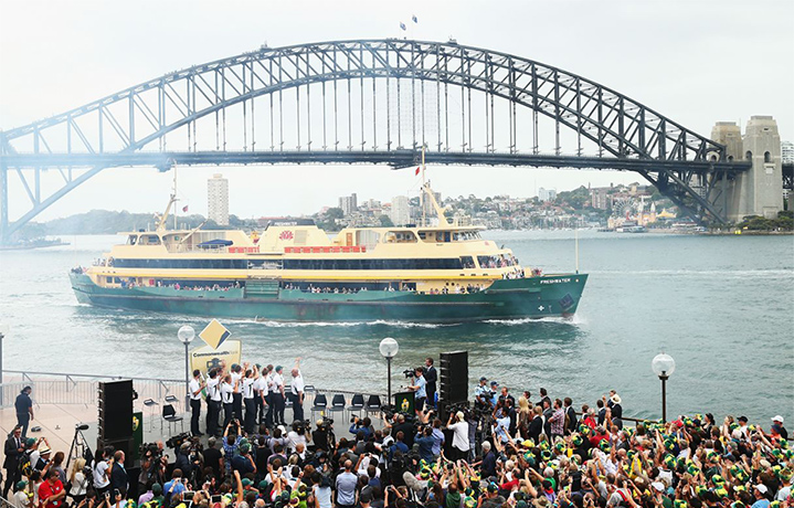 Celebrations: Players wave to the passengers on the Manly Ferry