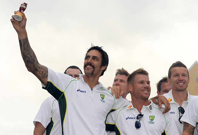 Celebrations: Mitchell Johnson holds up a replica Ashes urn 