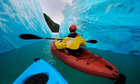 Sea kayaking near iceberg off Alaskan coast