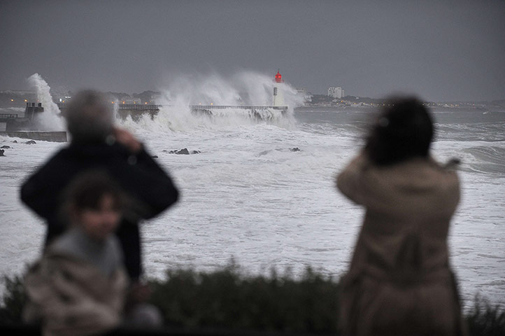 Stormy weather: People take pictures of a wave hitting t