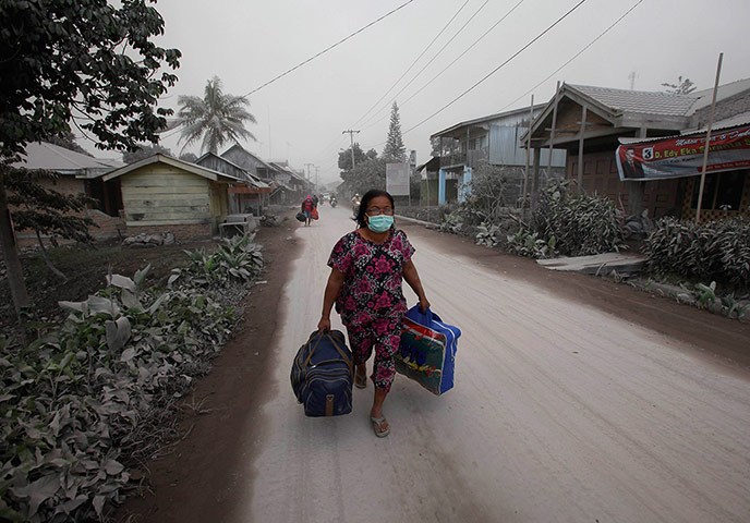 Mount Sinabung volcano: A villager carries her belongings during an evacuation