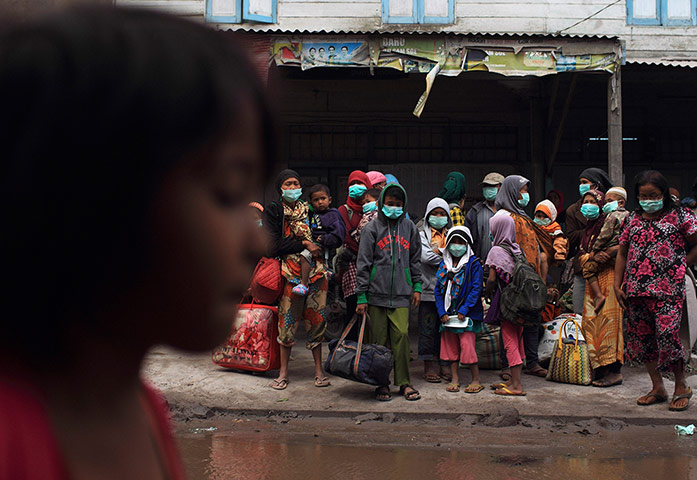 Mount Sinabung volcano: Villagers carry their belonging as wait for evacuation 