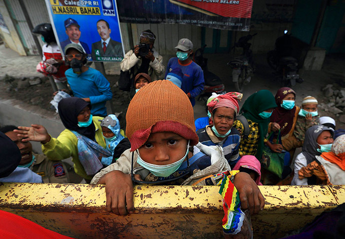 Mount Sinabung volcano: A child climbs onto a truck during an evacuation