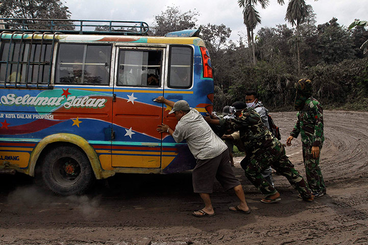 Mount Sinabung Volcano: Indonesian soldiers help push a public bus 