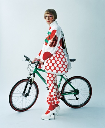 Grayson Perry in a spotty outfit with a bike