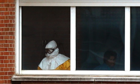 A medical practitioner wearing protective clothing treates an isolated patient on the sixth floor of the the Carlos III hospital in Madrid, Spain.