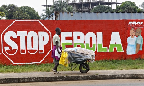 Man walks past Ebola mural in Liberia
