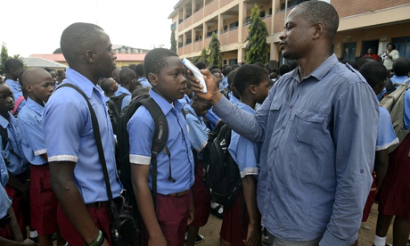 A teacher checks a pupil's temperature in Lagos, Nigeria, which has now been declared Ebola-free
