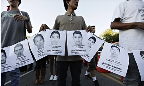 People hold photographs of missing students in Iguala
