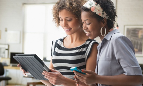 African American women using a tablet and smartphone