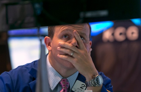 Specialist jason Notter works at his post on the floor of the New York Stock Exchange, near the close of trading, Friday, Oct. 10, 2014.