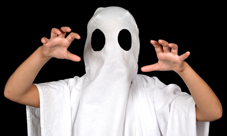 child dressed as a ghost, in a white sheet