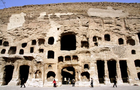 Visitors walk past the Yungang Grottoes near the city of Datong.