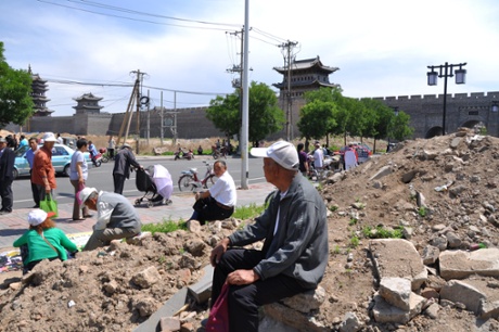 Datong, China. Taken outside the city walls. shows the rubble, but also the scene as it once was inside the wall - hustle bustle of city life.