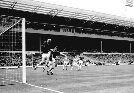 Wimbledon's Eddie Reynolds challenges the Sutton goalkeeper.