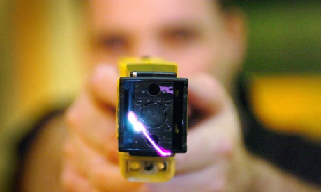 A police man firing a Taser