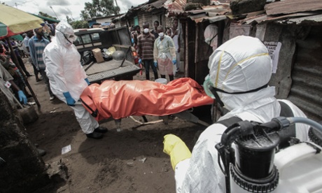 Liberian Red Cross workers supervise a burial team removing the body of 40-year-old Mary Nyanforh, in Monrovia.