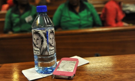 Bottled water and a mobile phone bearing the face of Reeva Steenkamp is seen in the Pretoria high court.