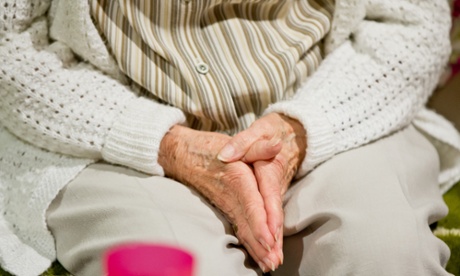 An elderly lady with her hands in her lap