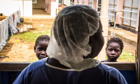 A healthcare worker speaks to children recovering from Ebola at a treatment centre in the Hastings area of Freetown, Sierra Leone.