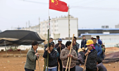 Villagers guard the entrance to Fuyou village in Yunnan province where the violence took place