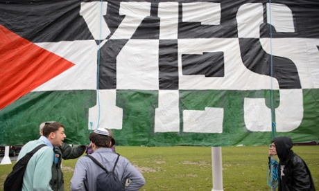 Young pro-Israel men argue with pro-Palestine supporters beside a giant banner calling for a recognised Palestinian state.