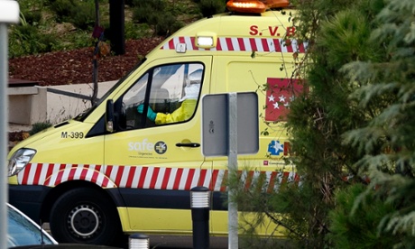 A paramedic drives an ambulance in a protective suit while leaving the Carlos III Hospital in Madrid, Spain.