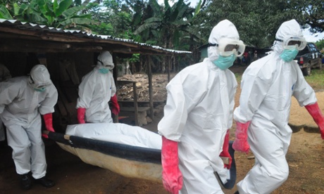 A burial team in protective gear carry the body of woman suspected to have died from Ebola in Monrovia, Liberia.