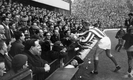 29th April 1965:  Sir Stanley Matthews, aged 50, presents a souvenir ball to the spectators before playing a farewell match for the Stanley Matthews XI against a World XI at Stoke City's Victoria Ground, where he began his career 33 years earlier.  (Photo by Douglas Miller/Keystone/Getty Images)England;black&white;formatlandscape;Sport;Football;Personality;British;Europe;KEY779370;KEY/SPORT/FOOTBALL/PORT/MATTHEWS/STANLEY/BOX147