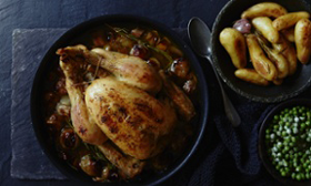 Roast chicken, potatoes and peas on table