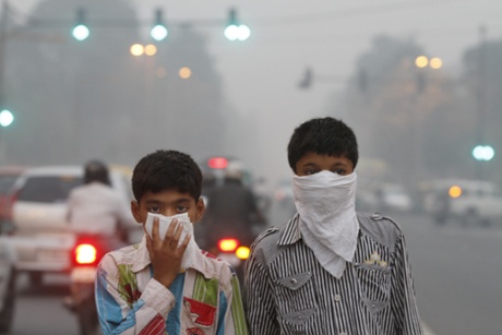 Children cover their faces as a precaution from the air pollution, New Delhi, India.