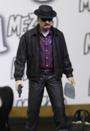 A Walter White Breaking Bad doll, complete with gun and meth.