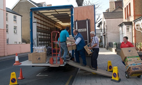 Four men loading a removals lorry with cardboard boxes in Aberystwyth Wales.