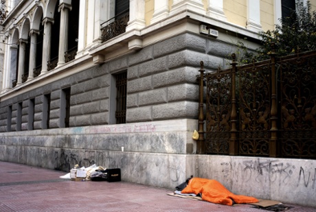 Homeless people sleep on Panapestimiou Street in Athens.