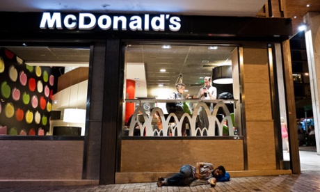 A man sleeps in front of a McDonald's restaurant in central Athens.