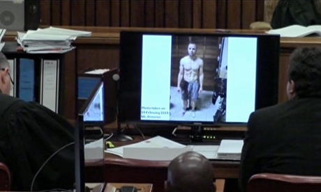 An image from the court showing on screen a police photograph of Oscar Pistorius standing on his blood-stained prosthetic legs.